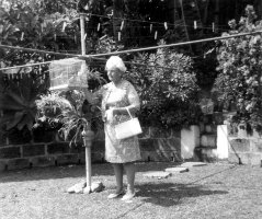 Mary MacLean Macky in back yard with budgie cage and clothes-line